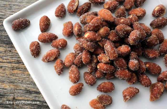 Ridiculously good honey roasted almonds, on a plate and ready to enjoy.