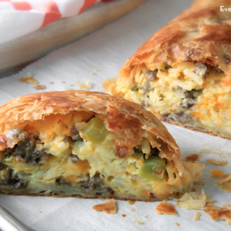 A delicious sausage breakfast stromboli that's cut in half and ready to eat.