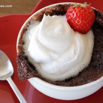Quick and easy 5 minute chocolate mug cake with whip cream and a strawberry garnish for Valentine’s Day