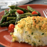 Light and delicious baked cod with lemon butter, on a plate and ready to eat for lunch or dinner.