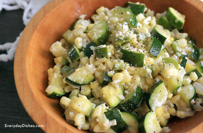 A bowl of light and creamy corn and zucchini, a vegetarian side dish.