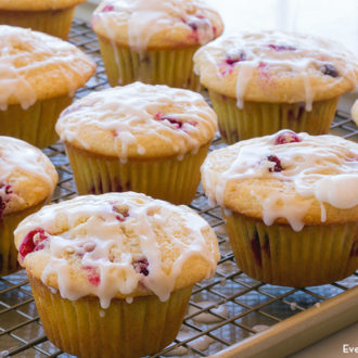 Freshly baked lemon cranberry muffins on a cooling rack, ready to enjoy.