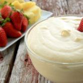 A bowl of sweet and creamy orange cream fruit dip that's perfect for dessert or a snack.