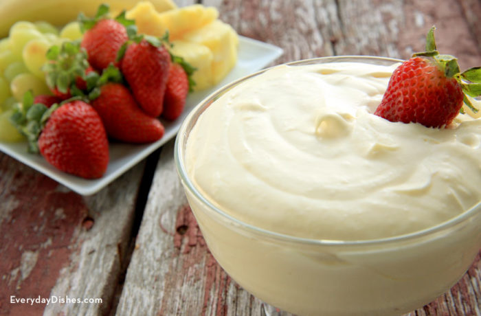 A bowl of sweet and creamy orange cream fruit dip that's perfect for dessert or a snack.