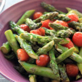 A bowl of savory and delicious vegetarian roasted asparagus and tomatoes.