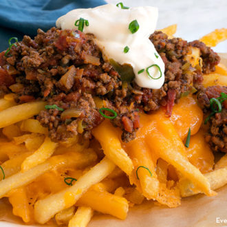 A plate of tasty homemade baked chili cheese fries.