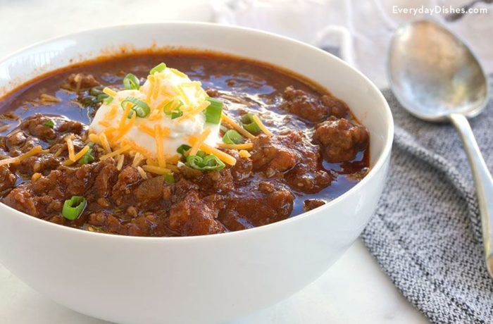 A bowl of bean-free chili, garnished with sour cream and cheese, ready to serve.