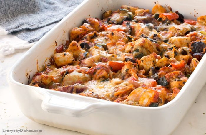 A dish full of a chicken casserole with roasted veggies that's ready to serve for dinner.