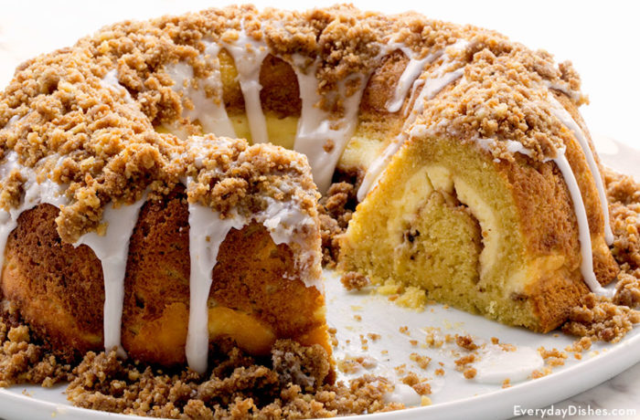A delicious, homemade cream cheese coffee cake, on a plate with one slice cut out.