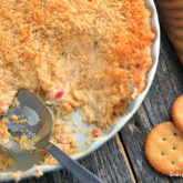 Delicious hot crab dip for an appetizer or snack on game day, served with crackers.