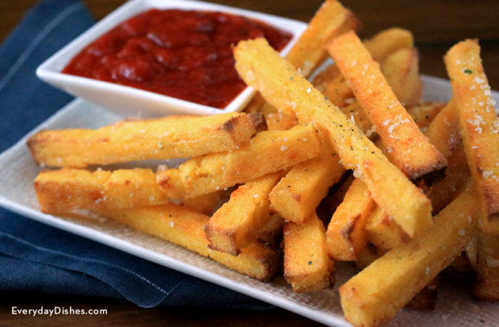 A homemade batch of parmesan polenta fries with a side of ketchup.