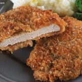 Some crunchy pork cutlets on a plate and ready to eat for dinner.