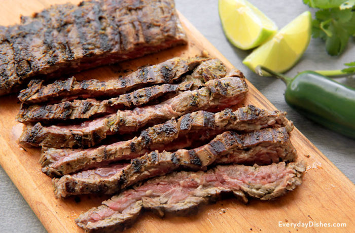 A delectable marinated skirt steak, sliced up on a cutting board and ready for dinner.