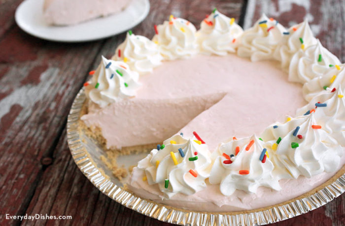 A freshly made no-bake lemonade pie with a slice cut out.