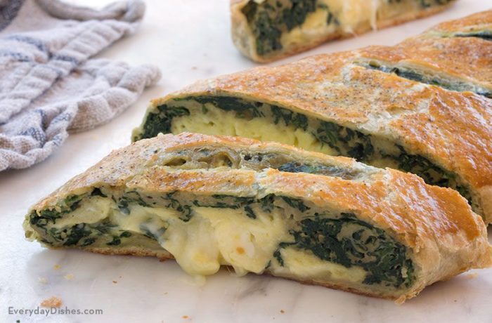 A spinach and egg breakfast stromboli that's sliced and ready to enjoy.