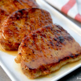 Sweet and tangy apple cider glazed pork chops, ready to serve for dinner.