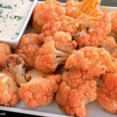 A batch of buffalo-flavored cauliflower with a side of ranch.