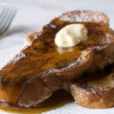 Two slices of easy French toast, topped with butter and syrup and ready to enjoy for breakfast.