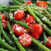 A serving of healthy sauteed green beans with cherry tomatoes.