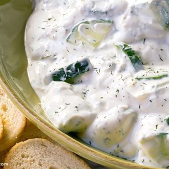 A delicious bowl of cucumber yogurt sauce served with baguette slices