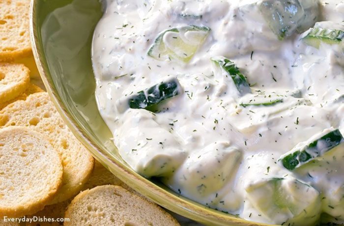 A delicious bowl of cucumber yogurt sauce served with baguette slices