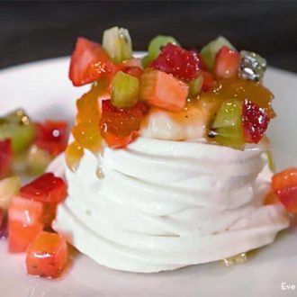 Gluten-free berry meringue on a plate and topped with fresh fruit.