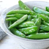 A bowl of sesame sugar snap peas — a healthy snack.