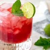 A refreshing glass of cranberry mojito with key lime