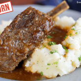 A braised short rib with einkorn flour on a plate with mashed potatoes.