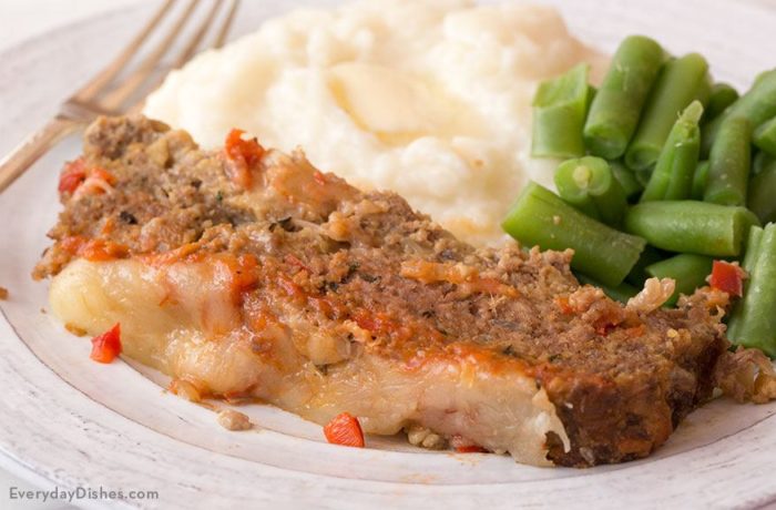 A dinner plate with homestyle Italian meatloaf, mashed potatoes, and green beans.