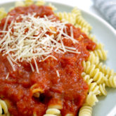 A plate of pasta with homemade marinara sauce and parmesan cheese. A delicious dinner.