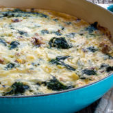 A skillet full of chicken sausage and spinach frittata, a great recipe to make ahead.