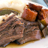 A plate of delicious, easy pot roast with a side of mashed potatoes.