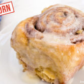 A delicious einkorn cinnamon roll on a plate and ready to enjoy.