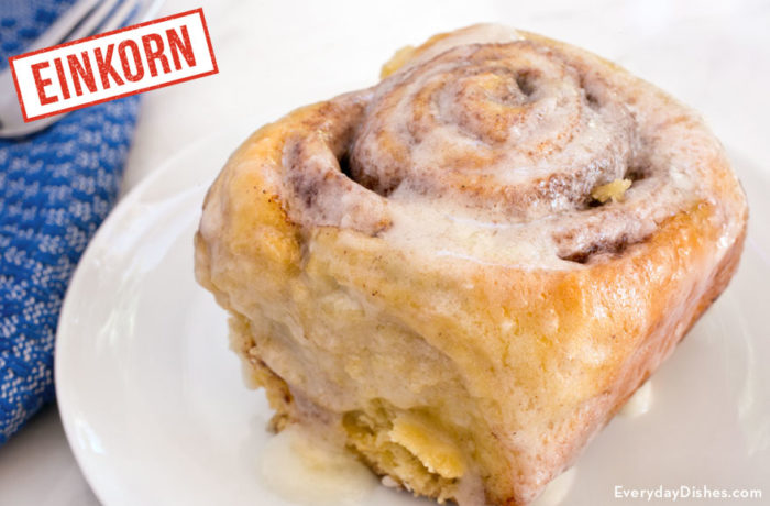 A delicious einkorn cinnamon roll on a plate and ready to enjoy.