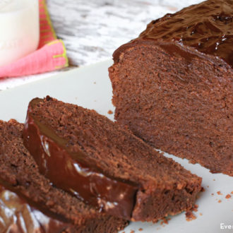 A homemade glazed chocolate pound cake that's sliced and ready to have for dessert.