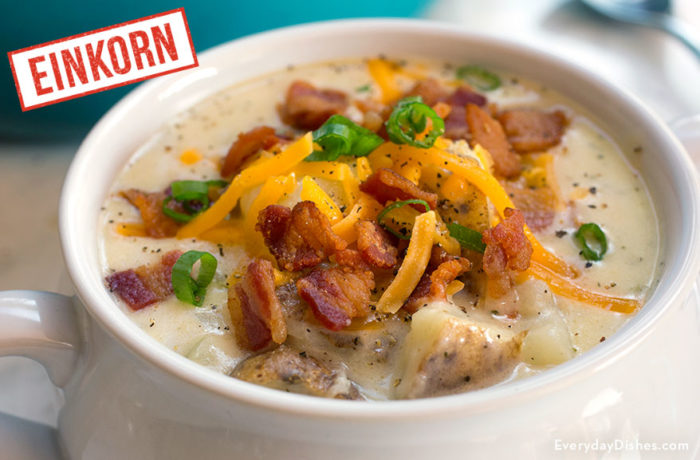 A bowl of einkorn loaded baked potato soup, garnished with bacon and cheese.