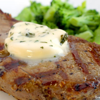 A steak with a dollop of homemade basil butter on top of it.