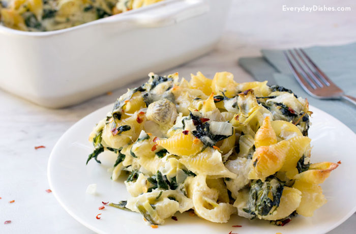 A plate with a serving of spinach artichoke pasta casserole.