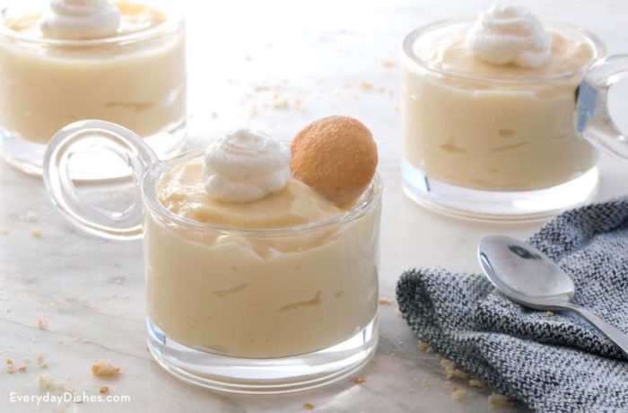 Three cups full of homemade vanilla pudding topped with whipped cream and garnished with nilla wafers.