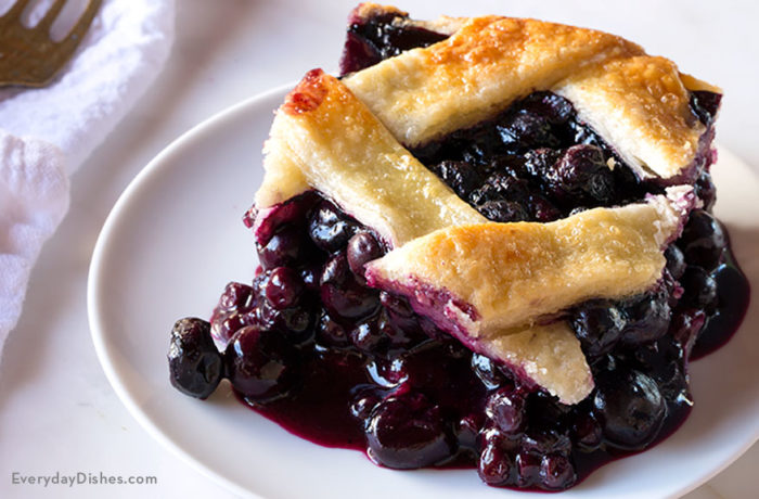A piece of a delicious blueberry slab pie with a lattice crust.