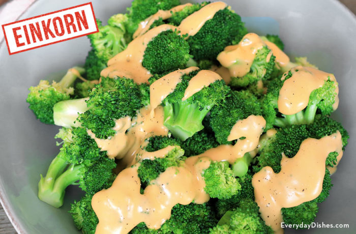 A bowl of steamed broccoli with einkorn cheese sauce.