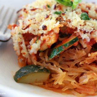 A slice of vegetarian spaghetti squash casserole on a plate and ready to eat for dinner.