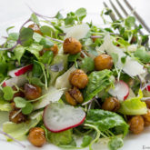 A plate with a serving of microgreens salad with roasted chickpeas.