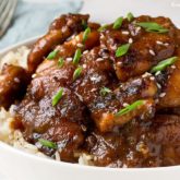 Easy bourbon chicken, in a bowl and served with rice.