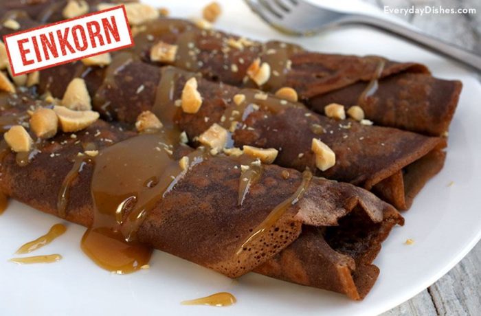 A plate of chocolate crepes with peanut butter sauce.