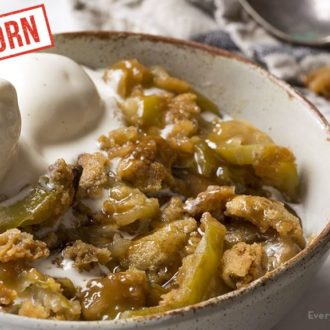 A serving of einkorn caramel apple crumble with a scoop of ice cream.
