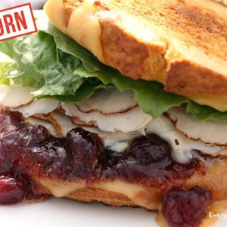 A leftover turkey sandwich with gouda and cranberry sauce.
