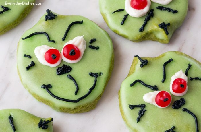 A fresh batch of cookies decorated to look like the Grinch made with matcha green tea.