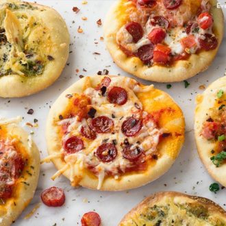 Several mini pizza appetizers, all with different toppings